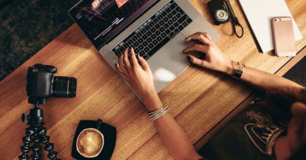 Top Ansicht auf einen Schreibtisch mit Laptop und Videocam in unserem Media Creation Expert Kurs