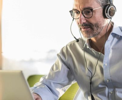 Ein Mann sitze mit Headset an einem Laptop in unserem Digitalisierungscoaching