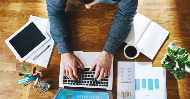 Ansicht von oben auf einen Mann der am Laptop tippt in unserem E-Commerce Coaching