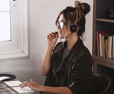 Frau mit Headset vor PC