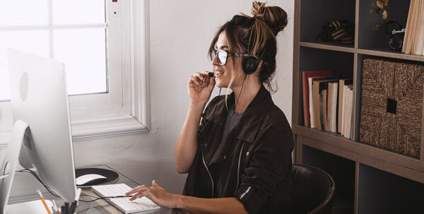 Frau mit Headset vor PC