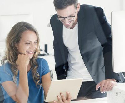 Mann und Frau schauen gemeinsam auf ein Tablet in unserem Social Media Coaching