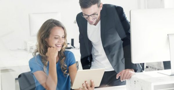 Mann und Frau schauen gemeinsam auf ein Tablet in unserem Social Media Coaching