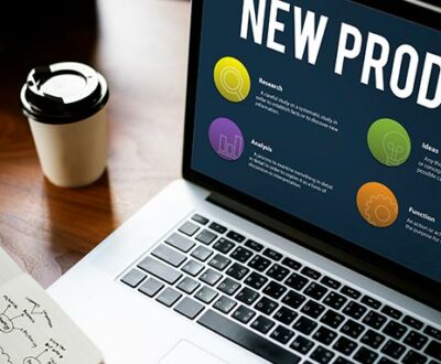 Ein aufgeklappter Laptop auf einem Schreibtisch, im Screen sichtbar steht New Produkt in unserem Online Marketing Coaching.
