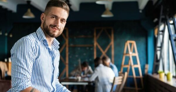 Junge Mann schaut zuversichtlich in die Kamera in unserem Gründercoaching