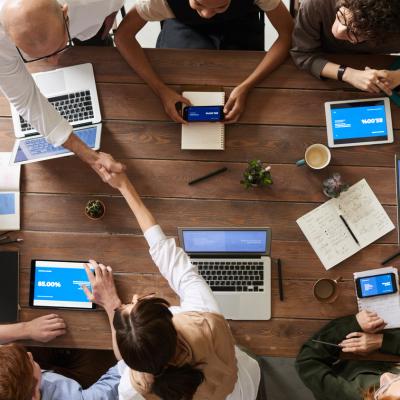 Anicht von oben auf eine Gruppe am Laptop arbeitender Menschen