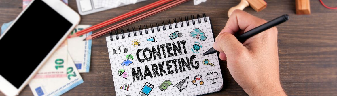 Schreibtischansicht von oben auf die Arbeit eines Content Marketing Managers mit Smartphone und Block.
